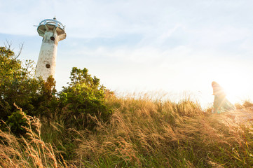 Young girl walking to the ancient lighthouse.