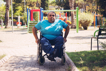 Obraz premium disabled man in wheelchair walking park