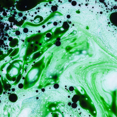 Abstract mixture of green and black ink