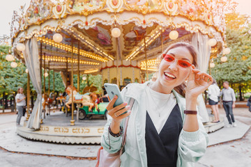 Asian woman with smartphone near Carousel in paris