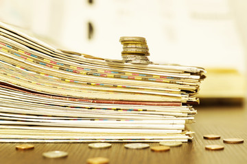 Newspapers and Money Cash. Stack of Daily Papers with News and Lots of Coins. Magazines and Journals for Business and Finance Concept 
