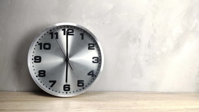 silver clock on wooden table
