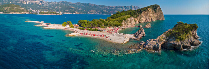 Aerial view of Sveti Nicola, Budva island, Montenegro. Hawaii beach, umbrellas and bathers and...