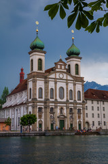 Fototapeta na wymiar Jesuit Church and buildings on waterfront of Reuss River, Lucerne, Switzerland 