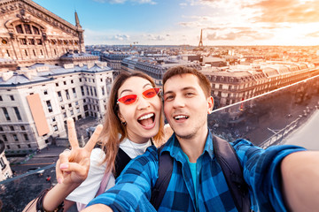 Loving couple Asian girl and European guy hug and take a selfie on the observation deck overlooking...