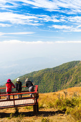 A group of tourists relaxing on the mountain peak.