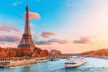 Foto op Plexiglas Eiffeltoren De belangrijkste attractie van Parijs en heel Europa is de Eiffeltoren in de stralen van de ondergaande zon aan de oever van de rivier de Seine met toeristische cruiseschepen