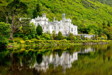 Kylemore Abbey with water reflections in Connemara, County Galway, Ireland, Europe. Benedictine monastery founded 1920 on the grounds of Kylemore Castle. Mainistir na Coille Moire - obrazy, fototapety, plakaty