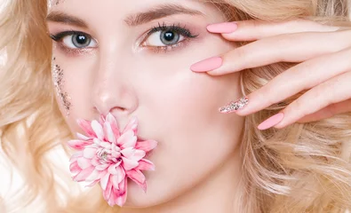 Fotobehang Beauty women portrait. half face of young curly blond woman with pastel manicure and perfect art make-up with glitter. Golden-daisy in her mouth. © Ксения Левашова
