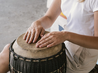 Young person with both hands on yuker drum