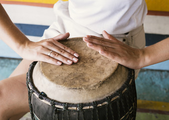 Young person playing yuker drum