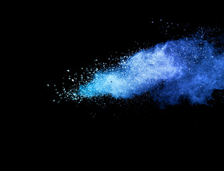 Blue powder explosion on black background.