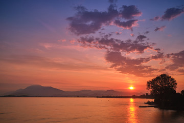 Fototapeta na wymiar Sunrise over the lake. Reflection of the sun in the water.