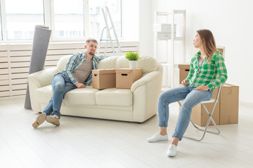 Positive smiling young girl sitting against her laughing in a new living room while moving to a new home. The concept of joy from the possibility of finding new housing.