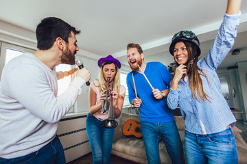 Group of friends playing karaoke at home. Concept about friendship, home entertainment and people