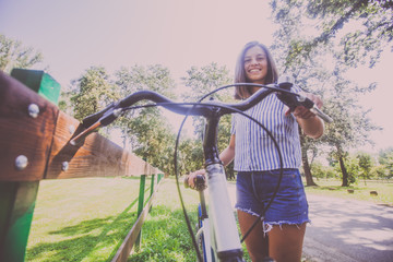 Pretty Young Woman Riding Bicycle In The Park