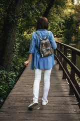 Young stylish woman with snakeskin python backpack.