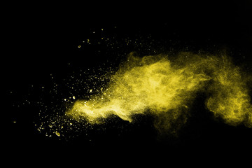 Fototapeta na wymiar Yellow powder explosion on black background.