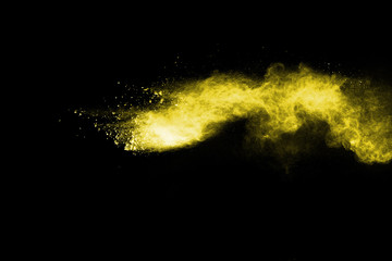 Yellow powder explosion on black background.