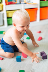 Cute baby boy playing with building blocks