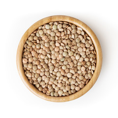 Uncooked lentils in wooden bowl isolated on white background with clipping path