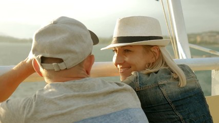 A man and woman in love looking at sunset from the deck of a cruise ship sailing the Mediterranean sea. Greece. 4K