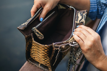Stylish woman with snakeskin handbag outdoors.