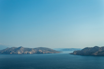 Fototapeta na wymiar Seascape: rocky islands, turquoise water, bright blue sky. Natural natural gradient of blue tones. Baska, island of Krk, Croatia.