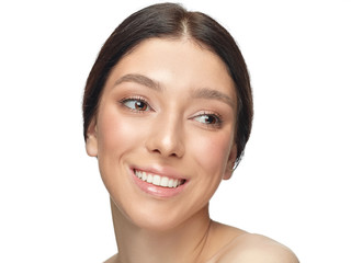 Obraz premium Portrait of beautiful young woman isolated on white studio background. Caucasian healthy female model looking at side, smiles pretty. Concept of women's health and beauty, self-care, body, skin care.