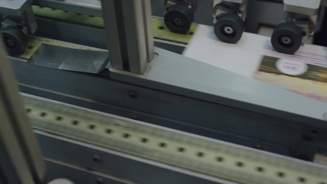 Papier wird auf einem Fliessband gefaltet - Paper is getting folded by a machine