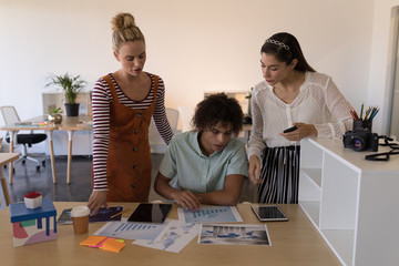 Business colleagues discussing over graph in office