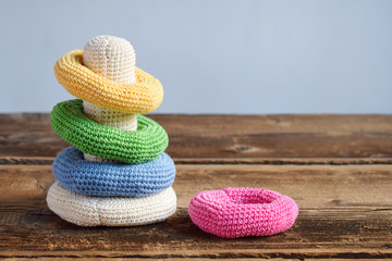 Crochet pyramid from colored rings. Toy for babies and toddlers to learn mechanical skills and...