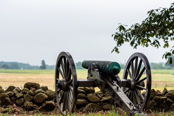 A Civil War era cannon is placed behind a stone wall in Gettysburg, PA - image