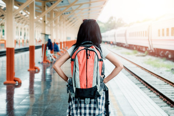 Traveling woman with backpack at the train station.