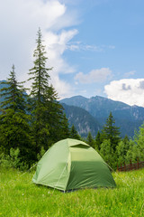 one green tent installed in the wild mountain scenery