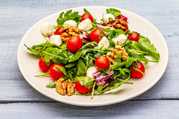 Fresh salad with arugula, radicchio, tomato cherry, baby mozzarella, walnuts