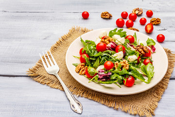 Fresh salad with arugula, radicchio, tomato cherry, baby mozzarella, walnuts