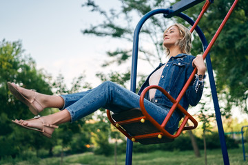 Carefree happy woman on swing outdoors
