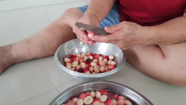 A Thai woman is splitting Karonda Fruits by a knife fruit for make herbs food
