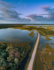 Lake Kaieris and a lonely road, located in the Kemeri National Park west of the city of Jmala captured from above with a drone.