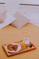 Breakfast in bed, orange juice and croissants with a cup of coffee