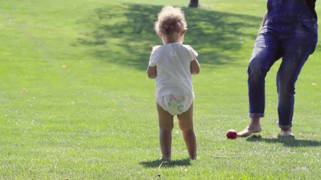 Happy baby girl throwing balls with her mother