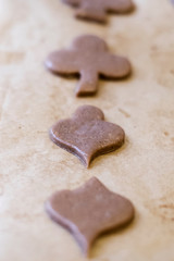 Backen in der Weihnachtszeit - Ausgestochene Lebkuchen-Plätzchen liegen zum Backen vorbereitet auf...