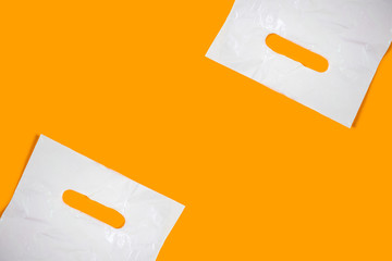 White plastic bags on an orange background. Minimalism, place for text.