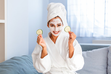 Natural homemade fresh cucumber facial eye pads facial masks. Woman holding cucumber pads and smile relax with natural homemade. Young woman with clay facial mask holding cucumber slices