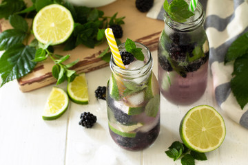 Homemade refreshing citrus lemonade mojito blackberry with  ingredients for making on wooden table. Free space for your text.