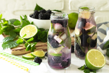 Homemade refreshing citrus lemonade mojito blackberry with  ingredients for making on wooden table.
