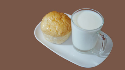Homemade bun and a cup of milk on white plate, Fresh breakfast