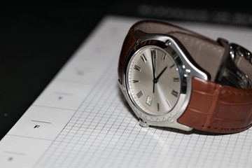 clock with arrows on a leather strap on a weekly plan