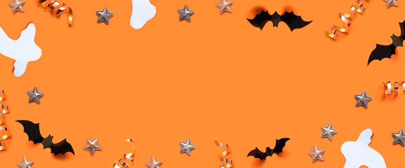 Halloween decor frame with bats, ghost, spider web, stars over a orange background.